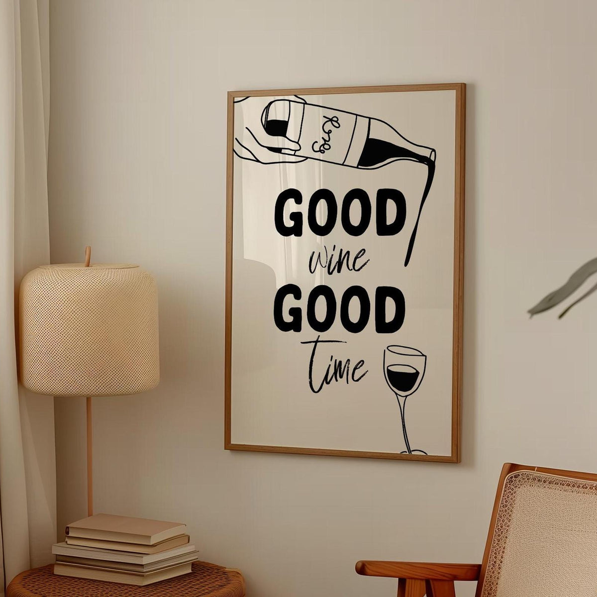Framed artwork with 'Good wine Good time' text in a room setting with a lamp and books.