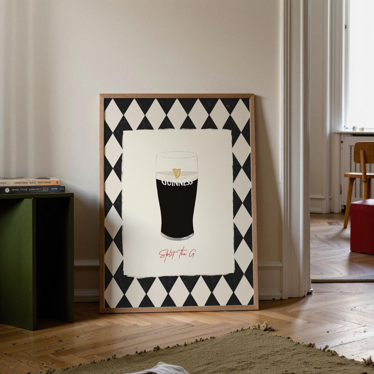Framed Guinness advertisement on a wall in a room with a green side table and open door.