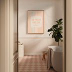 Bathroom interior with a framed quote on the wall, plant, and bathtub.