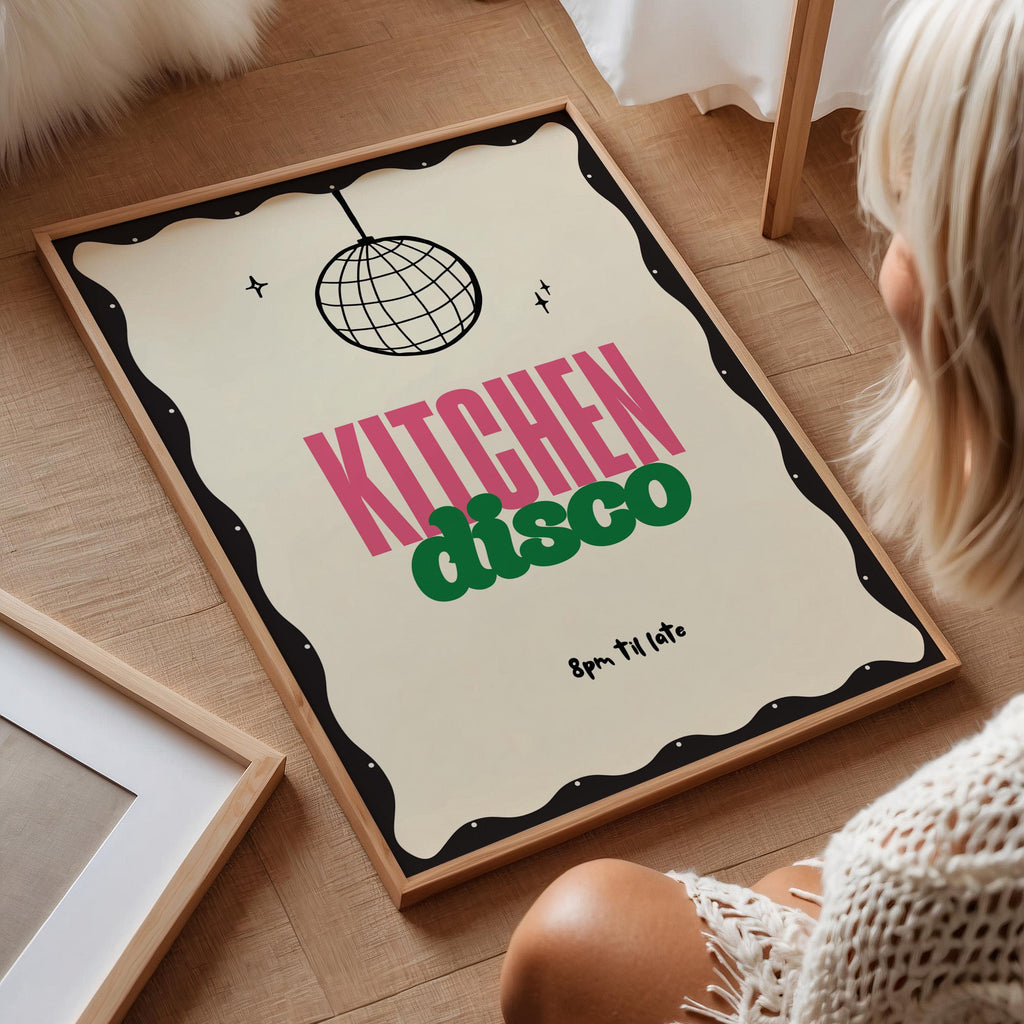 Framed poster with 'Kitchen Disco' design on a wooden floor.