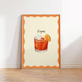 Framed artwork of a Negroni cocktail on a white wall.