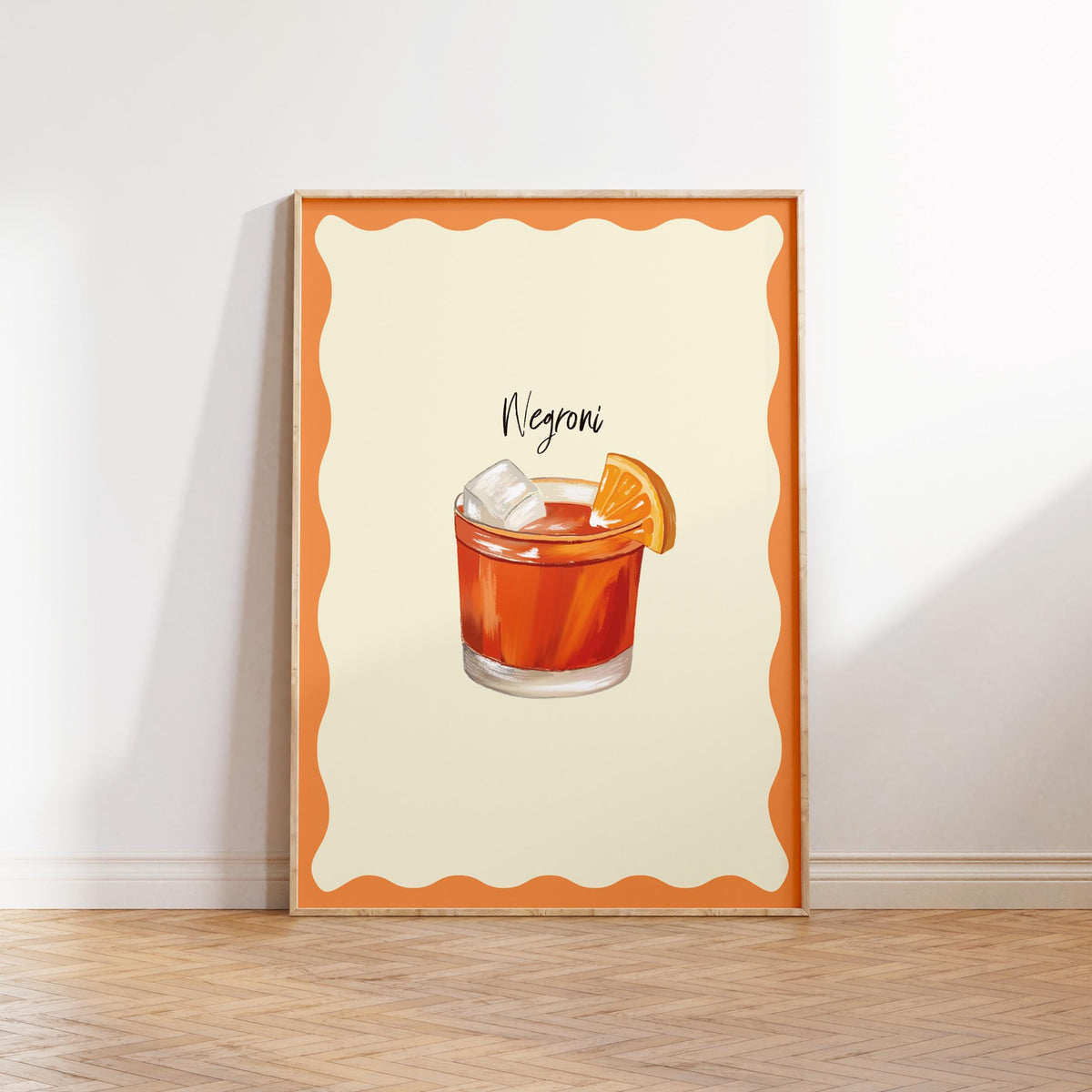 Framed artwork of a Negroni cocktail on a white wall.