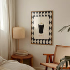 Room interior with a lamp, books, and a framed artwork on the wall.