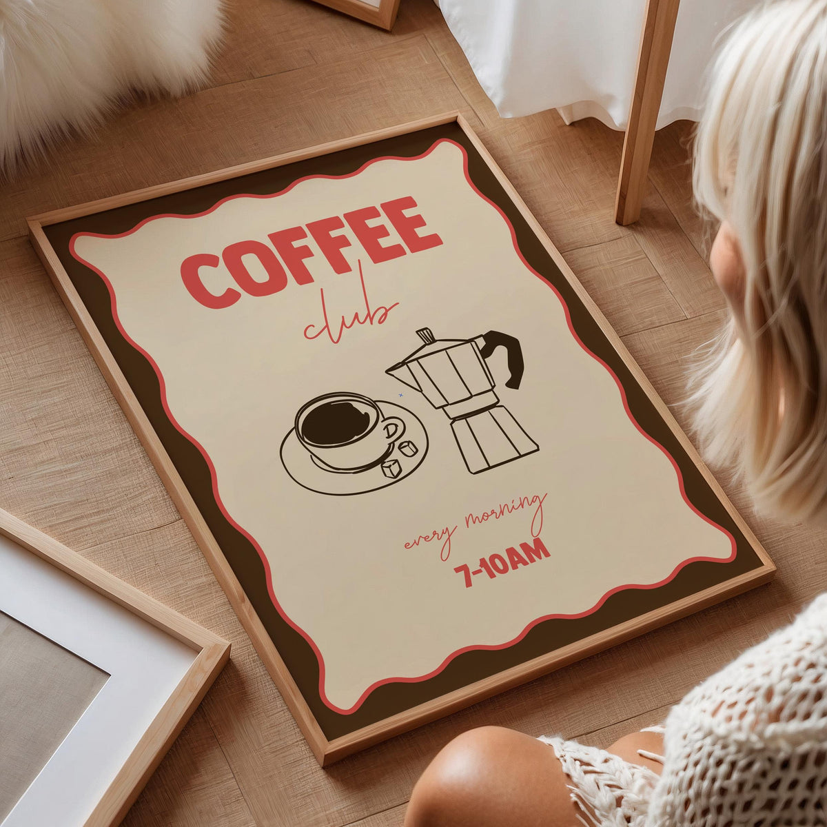Person sitting on a wooden floor with a 'Coffee Club' sign in front of them.