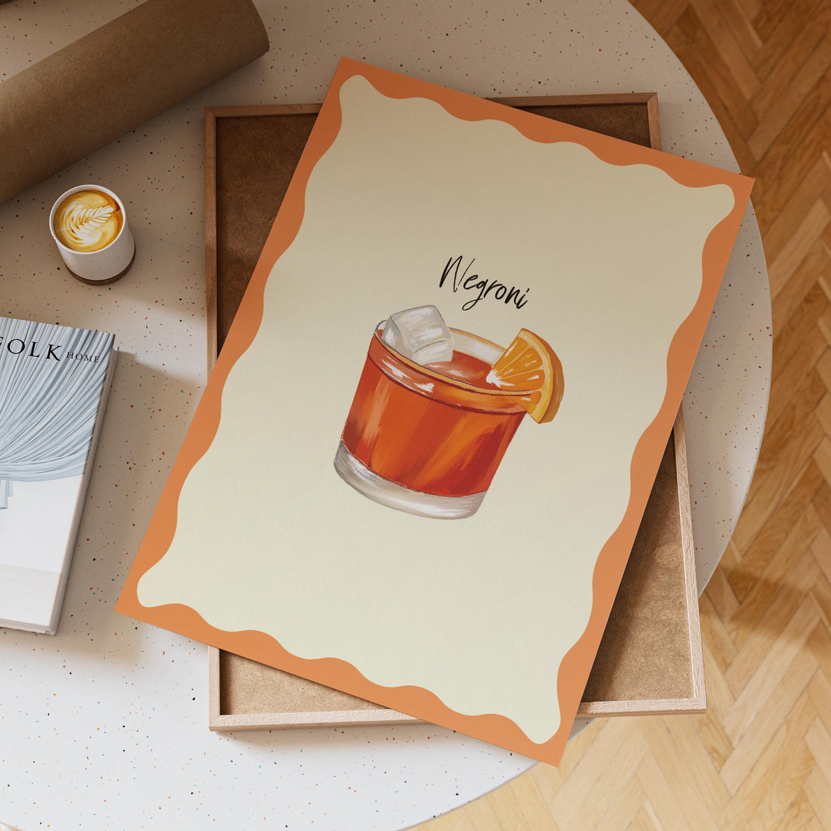 Notebook with Negroni illustration on a wooden surface with a cup of coffee.