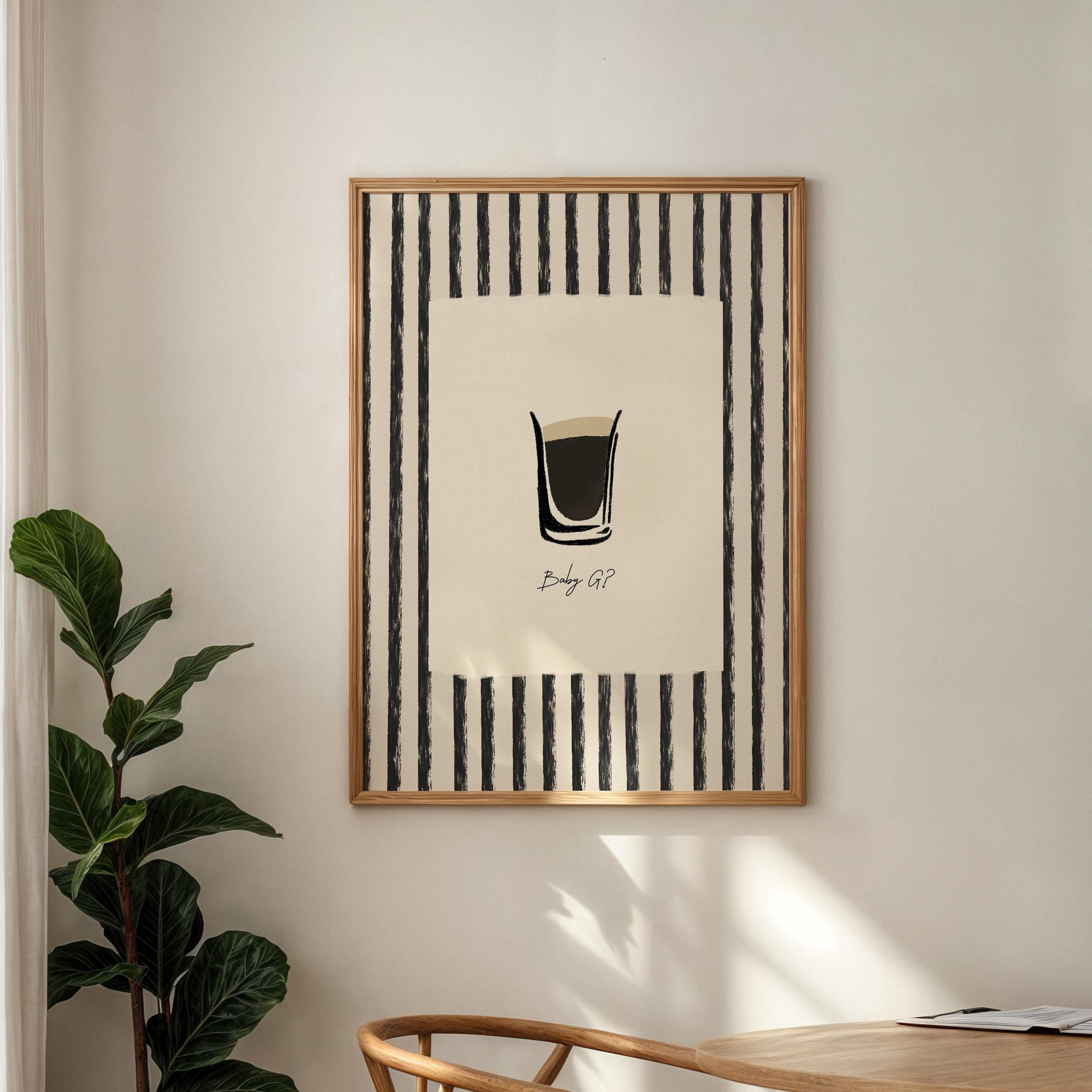 Framed artwork with a striped design on a wall next to a plant and wooden table.