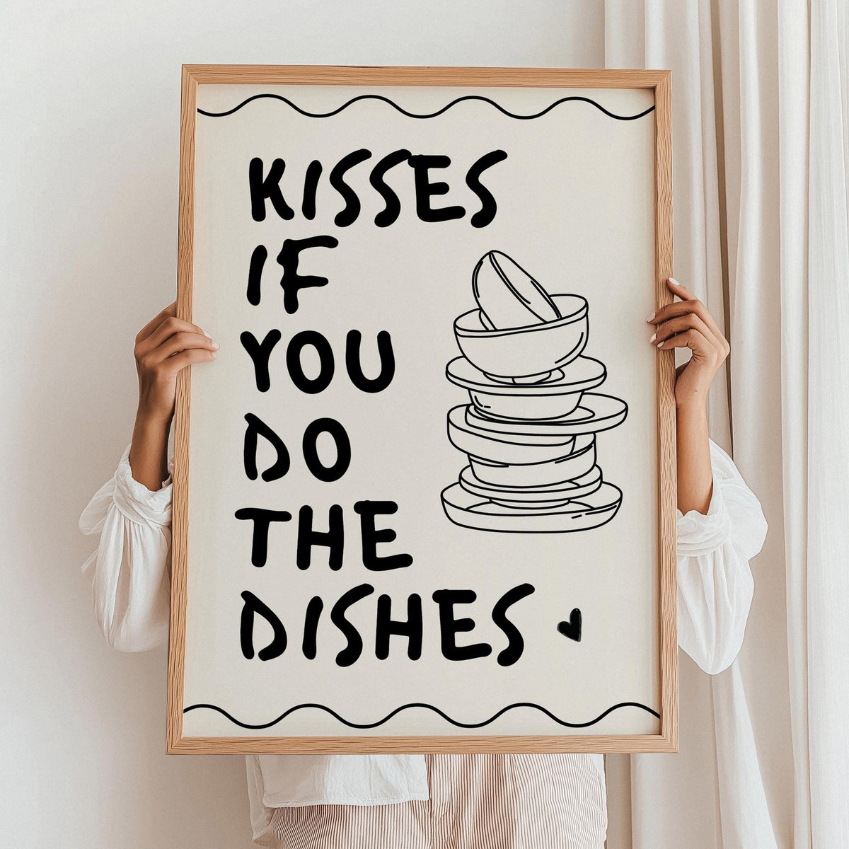 Person holding a framed print with text and a stack of dishes illustration.