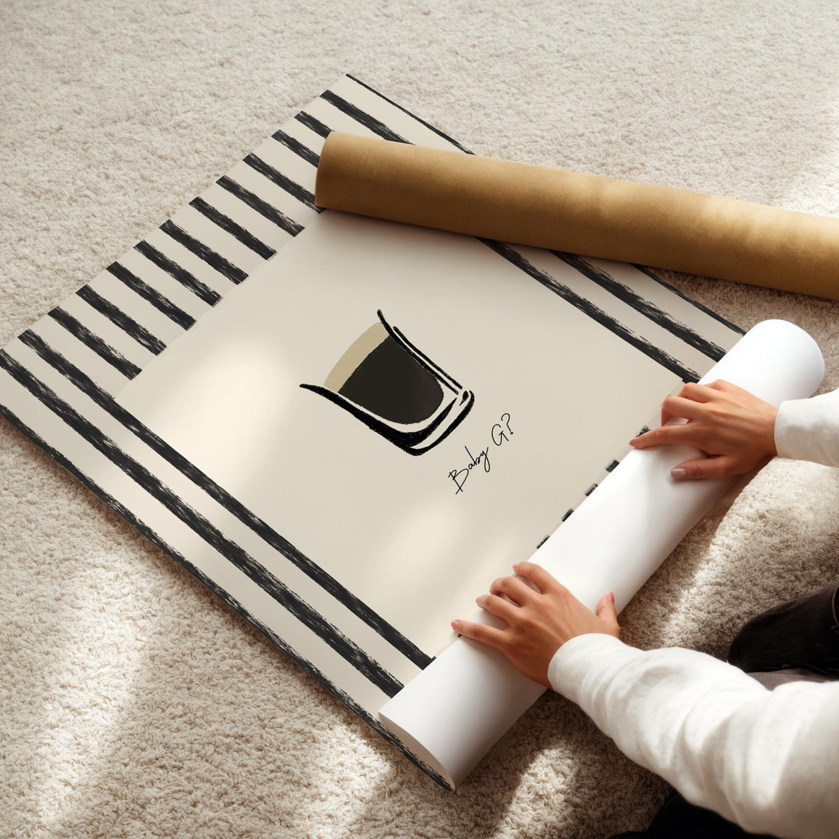 Person unrolling a large poster with a design on a carpeted floor
