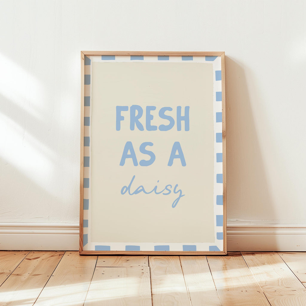Framed print with 'Fresh as a daisy' text on a wooden floor.