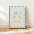 Framed print with 'Fresh as a daisy' text on a wooden floor.