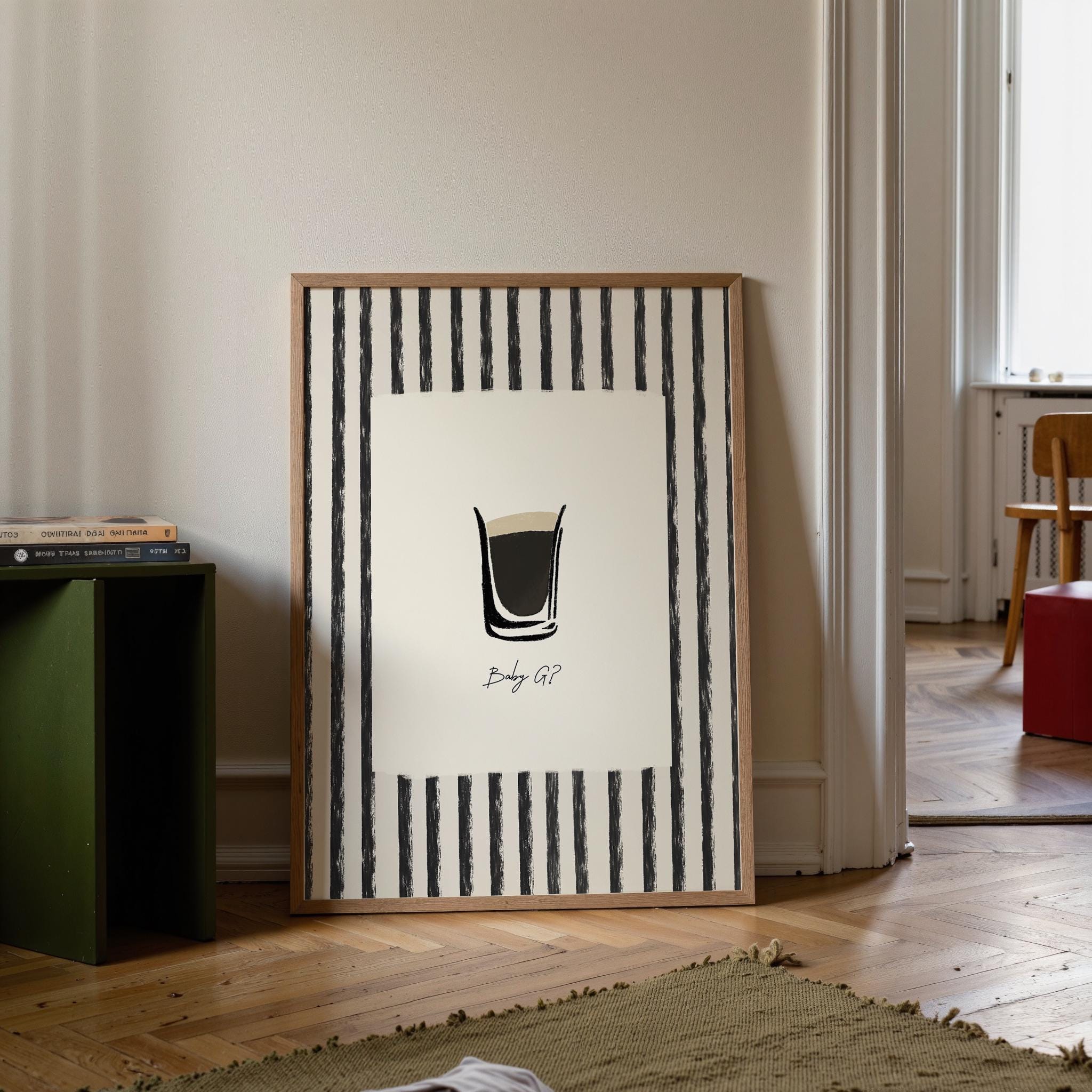 Framed artwork with a black and white design in a room with a green bookshelf and wooden floor.