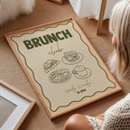 Framed poster with 'Brunch Club' text and food illustrations on a wooden floor.