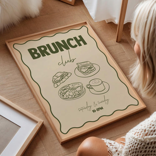 Framed poster with 'Brunch Club' text and food illustrations on a wooden floor.