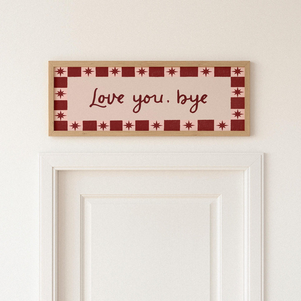 Decorative sign with 'Love you. bye' text on a wall above a door.
