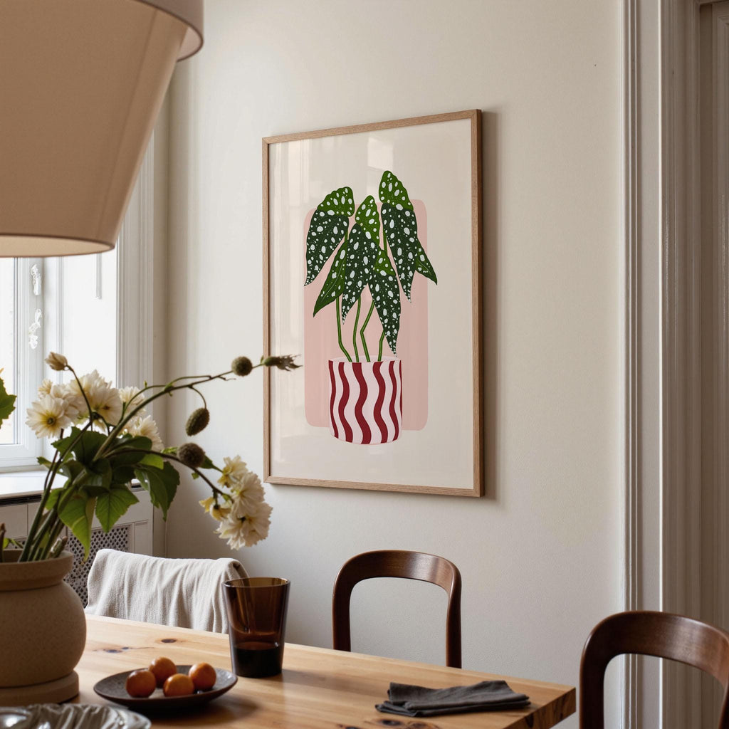 Dining room with a framed plant illustration on the wall, table with flowers and fruit, and chairs.