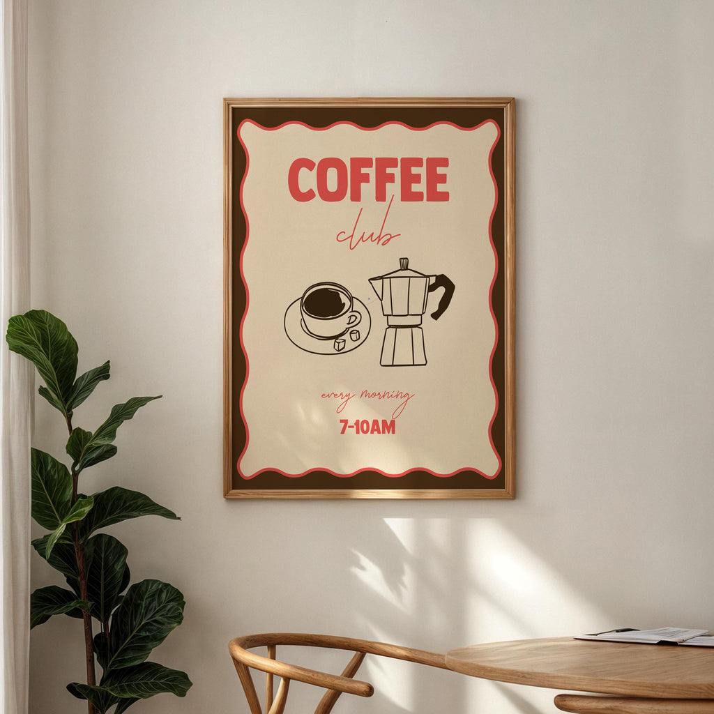 Framed poster with 'Coffee Club' design on a wall above a wooden table.