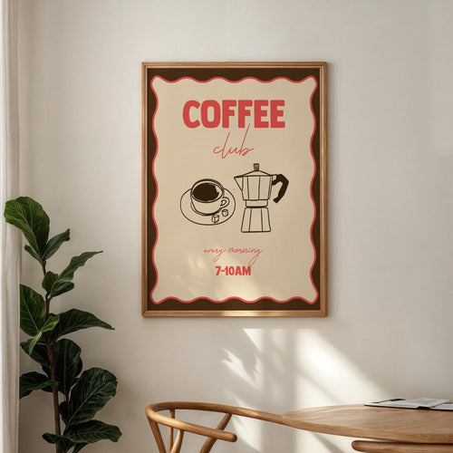 Framed poster with 'Coffee Club' design on a wall above a wooden table.
