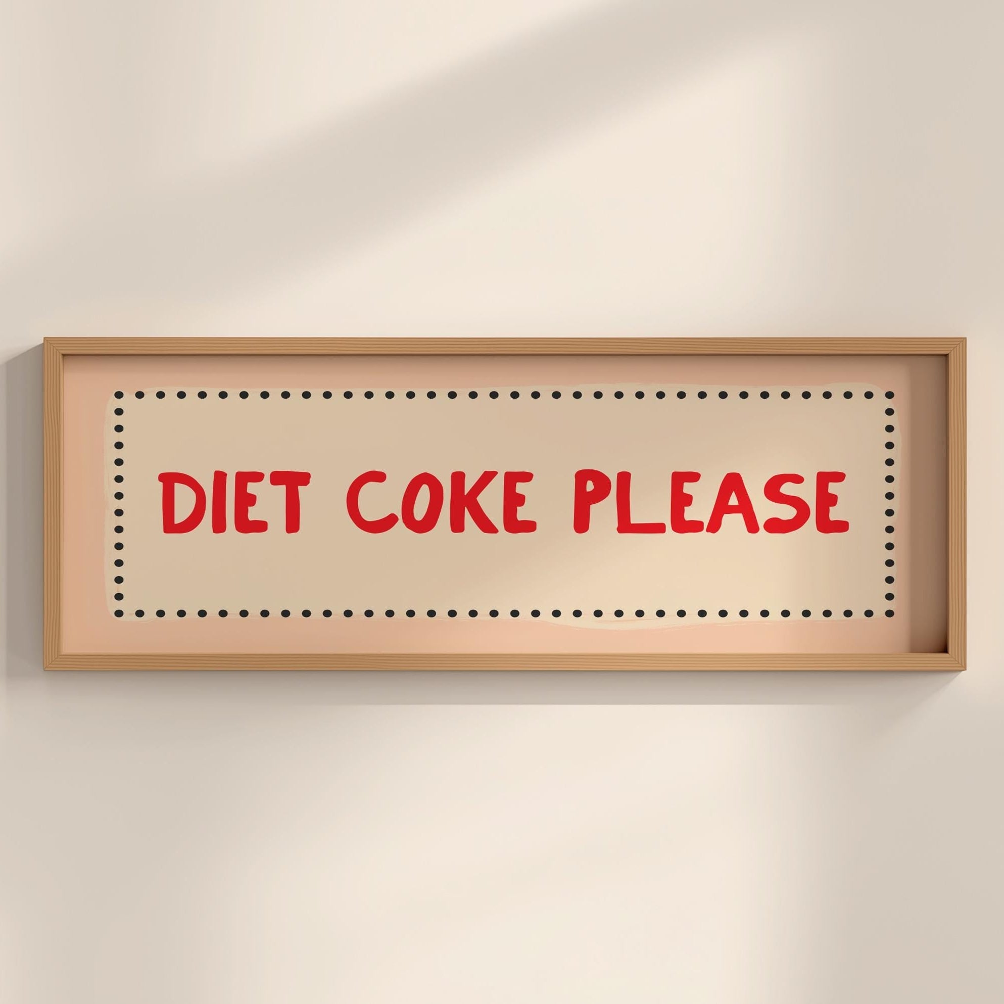 Framed sign with 'Diet Coke Please' text on a beige wall