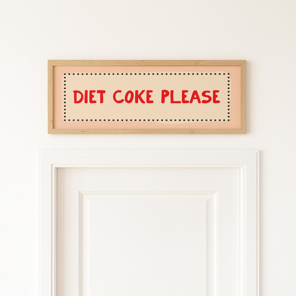 Wooden sign with 'Diet Coke Please' text on a white wall above a door.