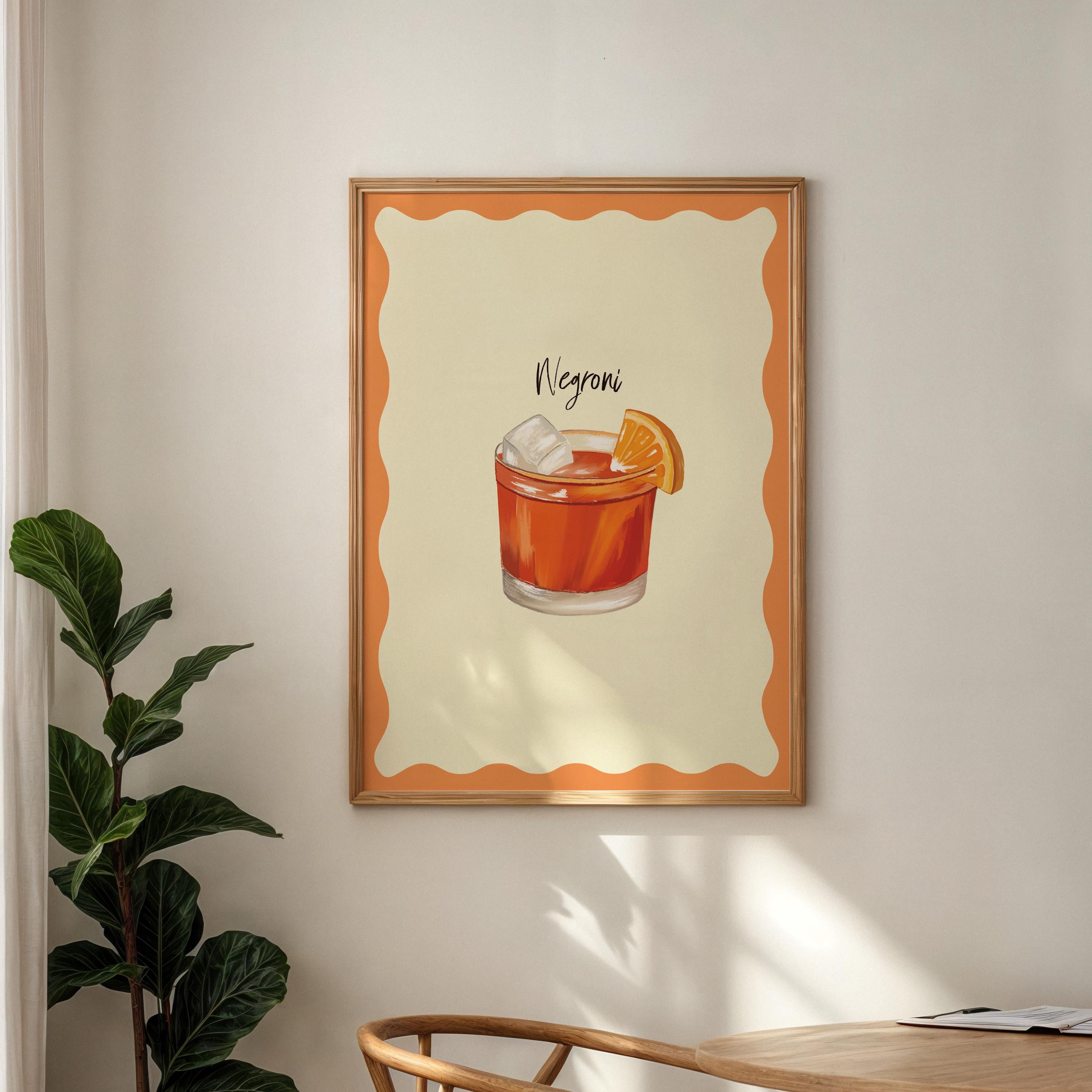 Framed artwork of a Negroni cocktail on a wall with a plant and table in the foreground.