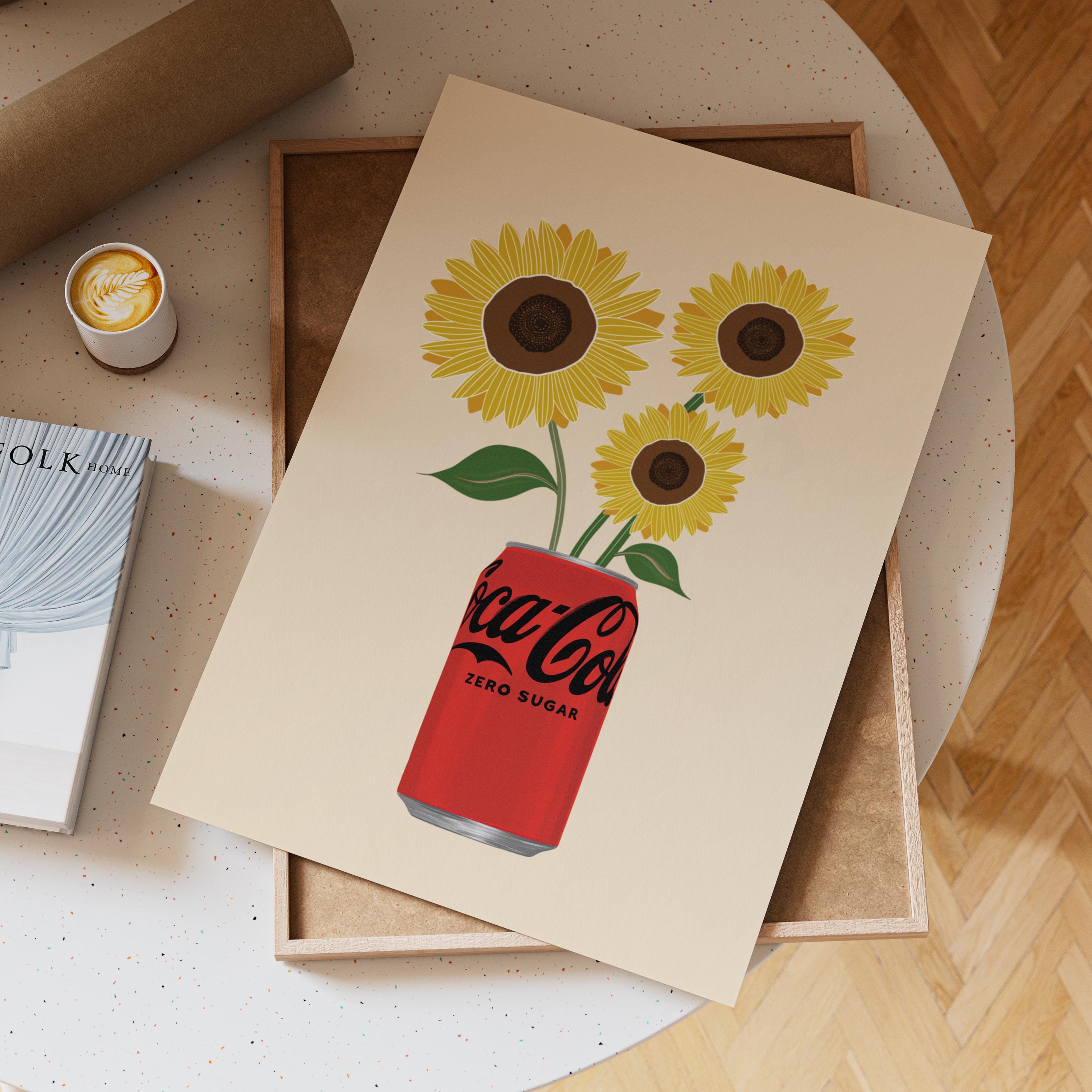 Notebook with Coca-Cola Zero Sugar design featuring sunflowers on a wooden surface.