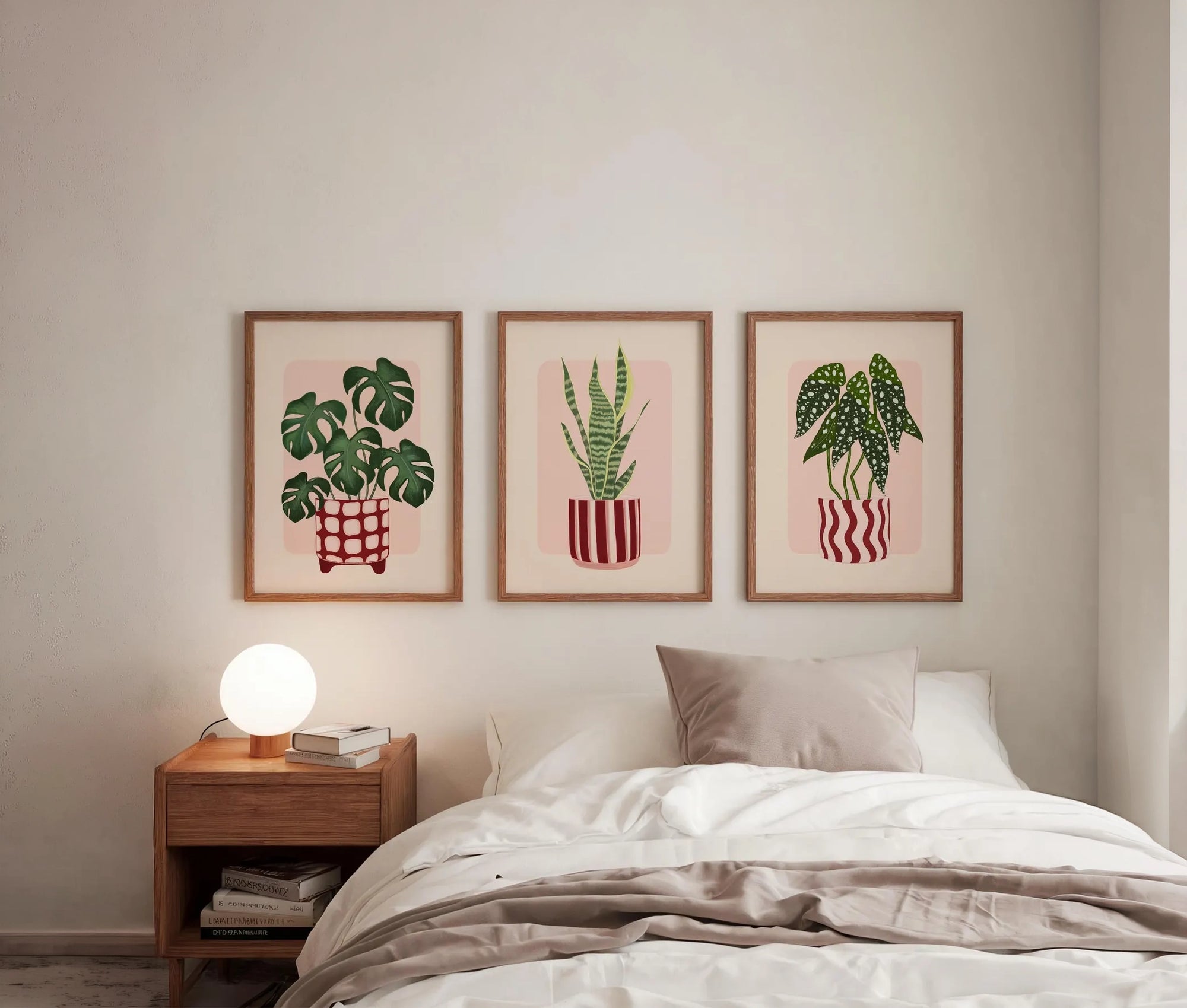 Bedroom with framed plant art on the wall and a nightstand with a lamp.