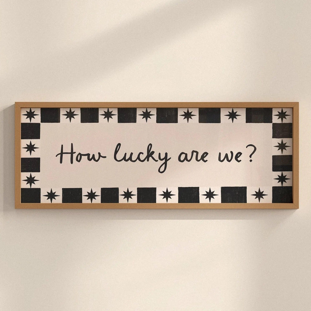 Decorative sign with 'How lucky are we?' text on a wall.