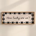 Decorative sign with 'How lucky are we?' text on a wall.