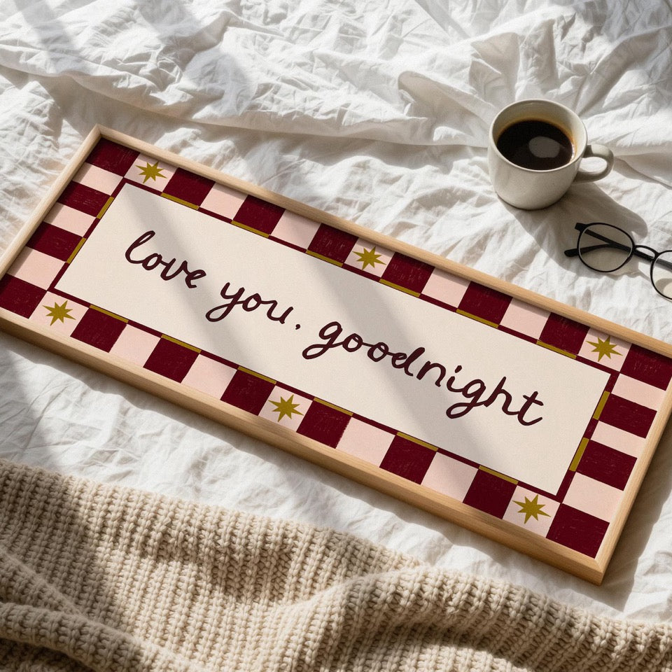 Decorative sign with 'love you, goodnight' text on a bed with a cup and glasses.