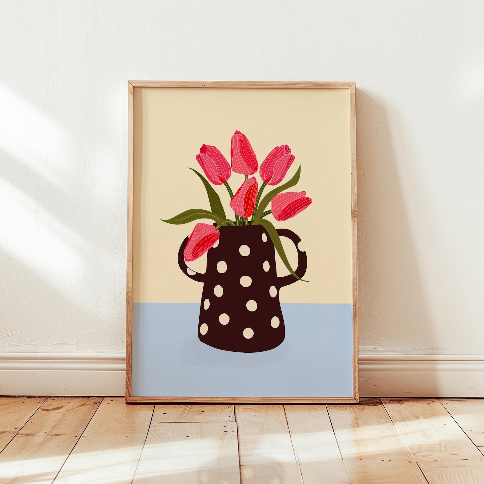 Framed artwork of a polka dot vase with red tulips on a beige and blue background.